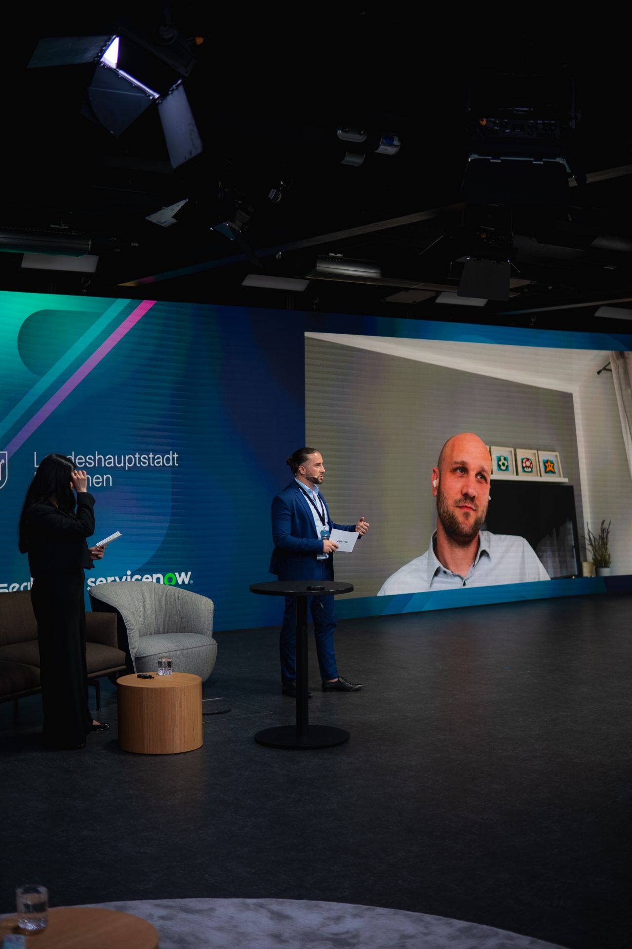 Hybrid panel — on-stage host with remote guest on the LED wall.