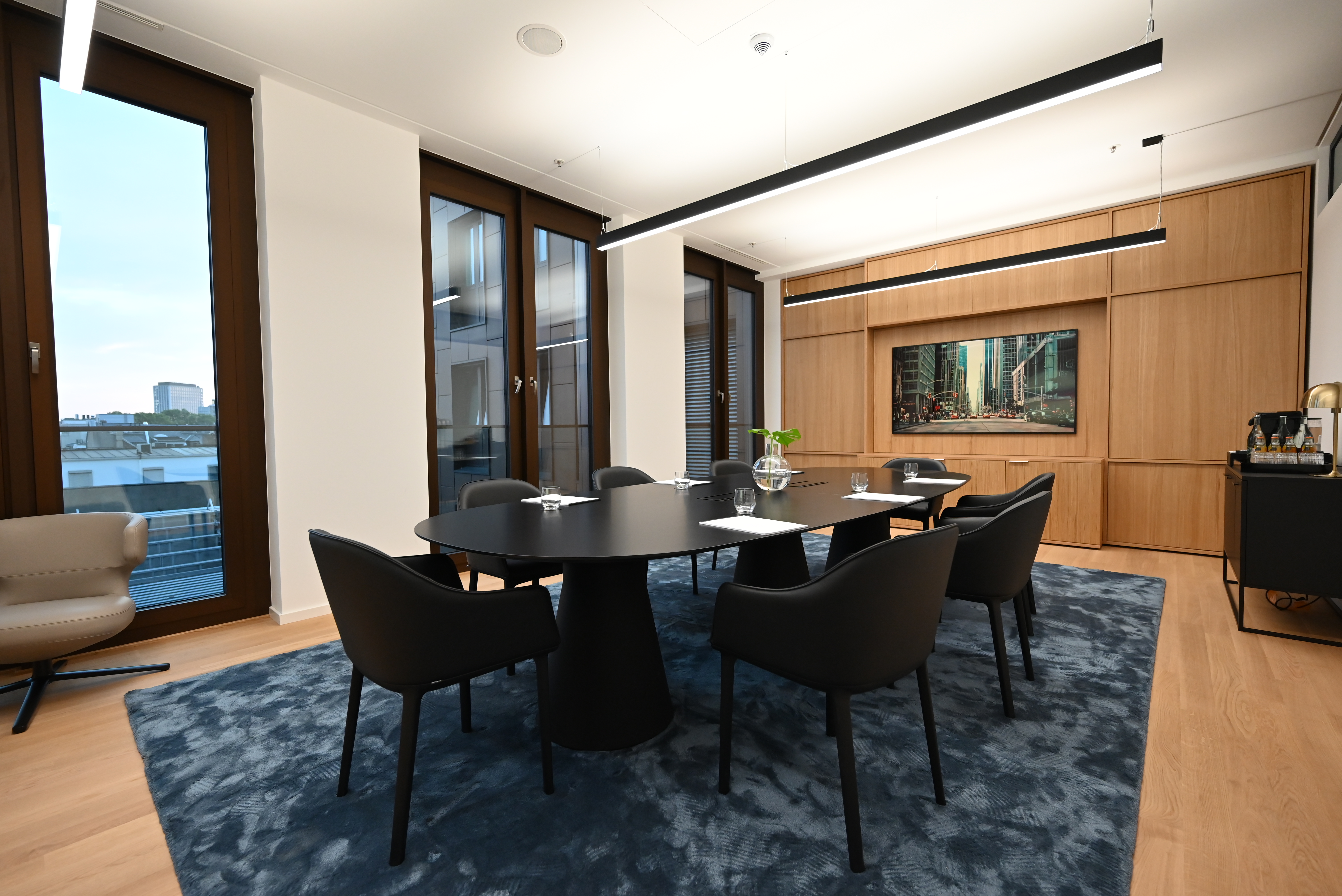 Directors Circle — 8-seat round-edge table on Floor 4, oak panelling and skyline artwork.